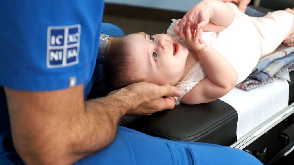 Dr. Theo Kousouli providing gentle spinal care for a newborn baby